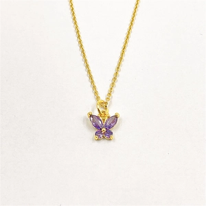 Détail d'un collier élégant en laiton doré avec pendentif papillon en zircone violette