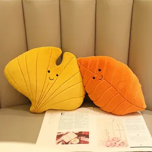 Cute cartoon leaf plush pillows with smiling faces in ginkgo and maple shapes