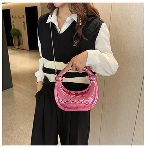 Detail showing bright pink crescent bag with rhombic texture and golden chain