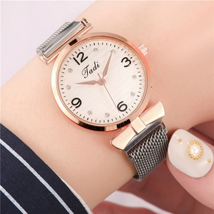Detail of rose gold ladies watch with grey Milanese strap and bow-shaped connector