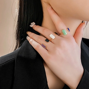 Close-up of elegant gold adjustable rings with colorful rectangular enamel inlay detail