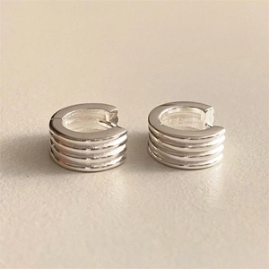 Macro shot of silver C-shape earrings featuring four parallel horizontal textured ridges
