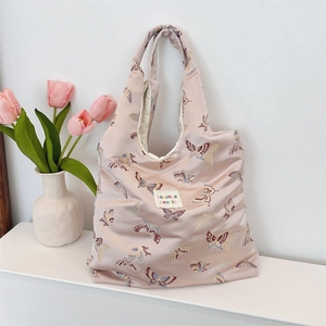 Detail of pink jacquard shoulder bag with butterfly patterns and leather strap