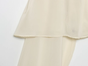 Detail of cream chiffon fabric showing layered hem stitching and lightweight texture