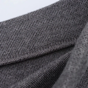 Primer plano de tejido de punto gris oscuro con detalles de costura y textura suave