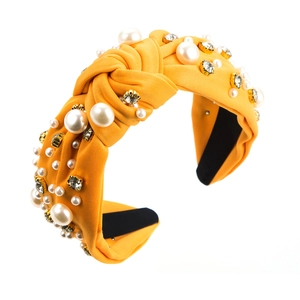 Gelber barocker Knotenstirnband aus Stoff mit Perlen und Strass auf weißem Grund