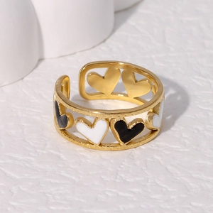 Golden open heart ring featuring black and white enamel details in a minimalist design