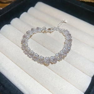 Detail view of double-layer beaded bracelet with pearls and purple crystal beads in jewelry box