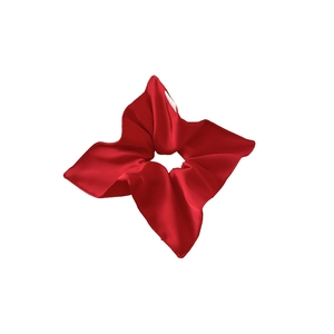 Glossy red satin scrunchie with a unique floral star shape on a white background