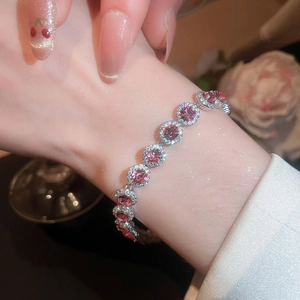Gros plan d'un bracelet en argent scintillant avec zircons roses porté au poignet