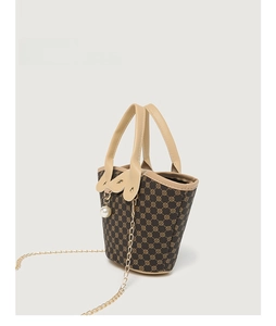Detail of monogram bucket bag with gold chain strap and elegant pearl pendant