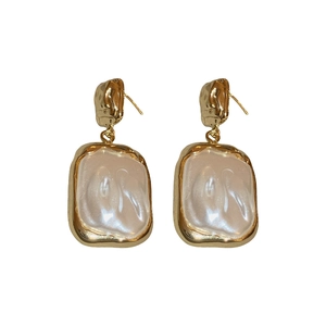 Vintage gold textured square earrings with central faux pearl insert on white background