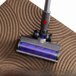 Close-up of vacuum cleaner cleaning brown non-slip door mat with wavy surface texture