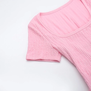 Détail du tissu plissé rose avec texture haute élasticité et finitions de couture