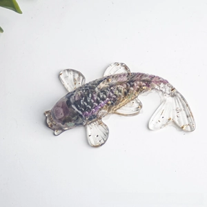 Top view of crystal resin koi fish figurine with purple stones and gold foil flakes
