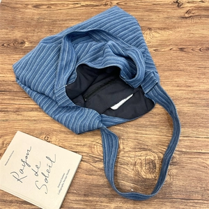 Top-down view of blue striped canvas tote bag showing interior lining and zipper pocket