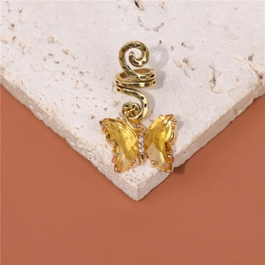 Golden butterfly ear cuff with yellow faceted crystals on a natural stone base