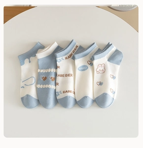 Dettaglio di cinque paia di calzini in cotone blu cielo e bianco crema con conigli
