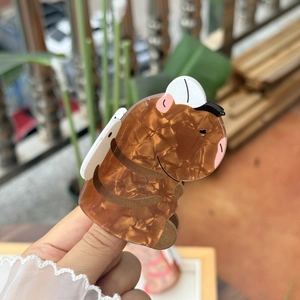 Détail d'une pince à cheveux capybara en acétate ambre avec texture marbrée