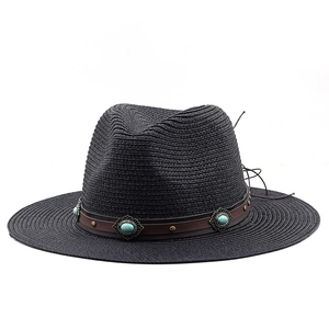 Dettaglio cappello in paglia nero con fascia in pelle marrone e decorazioni turchesi