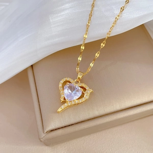 Close-up of golden heart pendant with a large central gemstone and sparkling diamond edge