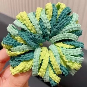 Vue détaillée de chouchous en tissu bulle vert avec texture plissée élastique