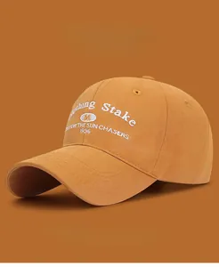 Detail of embroidered lettering on mustard yellow cotton baseball cap with multi-color options