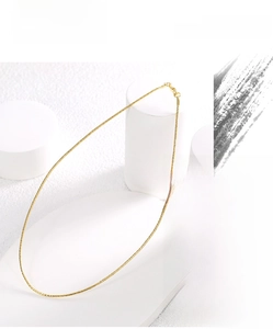 Close-up of a minimalist golden spring collar necklace on a white geometric background
