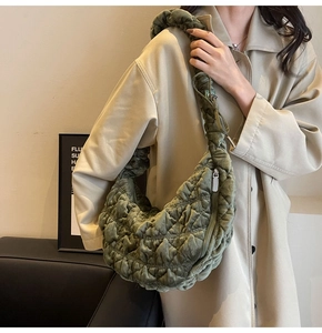 Detailed view of olive green quilted velvet cloud bag with pleated shoulder strap on model
