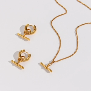 Detail of gold minimalist jewelry set featuring toggle bar pendants and chain