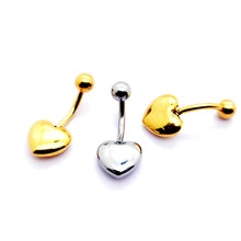 Detailed close-up of gold and silver heart-shaped navel rings with polished steel finish