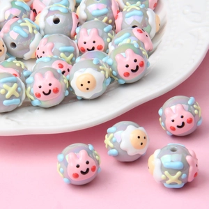Detailed view of hand-painted acrylic beads with pink rabbits and yellow sheep patterns