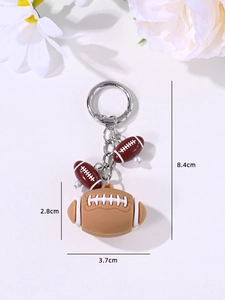 Detail view of brown American football keychain charms with white stitching and dimensions