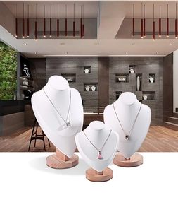 Three-piece white leather necklace display busts with natural wooden bases for jewelry