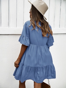 Vue arrière d'une robe bleue à volants avec un chapeau beige à larges bords