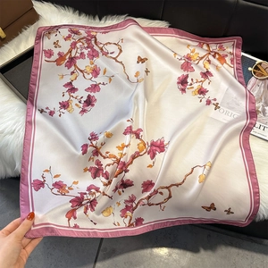 Nahaufnahme von Retro-Blumen- und Schmetterlingsdruck auf einem weichen Seidenschal