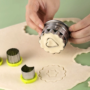 Stainless steel cookie cutter set with green handles for cutting dough shapes