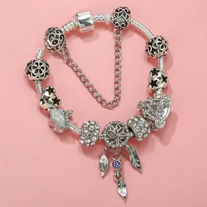 Detailed view of silver snake chain bracelet with heart, star, and tree charms