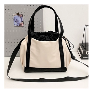 Detail of nylon tote bag showing the cream and black stitching and drawstring closure