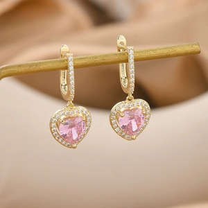 Macro view of gold-plated heart-shaped pink crystal earrings with micro-pave zircon detail