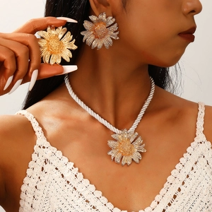 Detail of sunflower necklace with white braided cord and matching earrings on model
