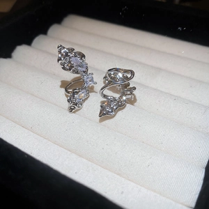 Detailed macro of liquid metal silver ear cuff with sparkling cubic zirconia on velvet