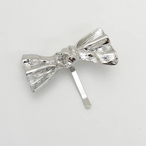 Macro view of textured silver metal bow hair clip with polished metallic finish