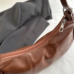 Chic dark brown faux leather crescent underarm bag with silver zipper and retro glossy finish