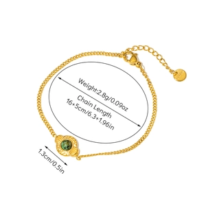 Detail of gold stainless steel bracelet featuring a green stone inlay and lobster clasp