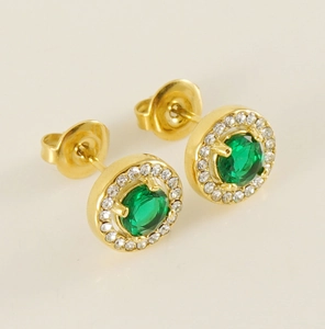 Close-up of gold stud earrings with a green gemstone center and clear zircon halo