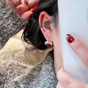Boucles d'oreilles pendantes baies dorées avec perles rouges et détails feuilles en zircon