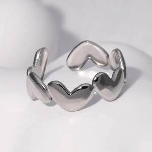 Bague ouverte argentée avec motifs de cœurs entrelacés et finition polie brillante