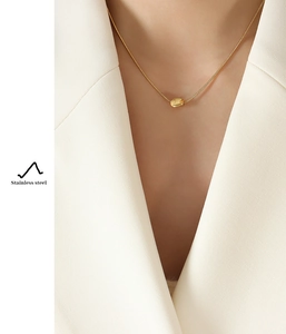 Dettaglio del ciondolo a tubo ritorto su collana a catena serpente in acciaio inossidabile 18k