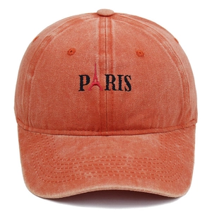 Detail of Paris embroidery and Eiffel Tower logo on washed orange baseball cap